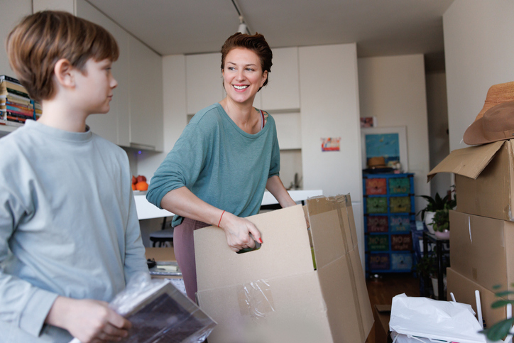 mother and son carrying moving boxes